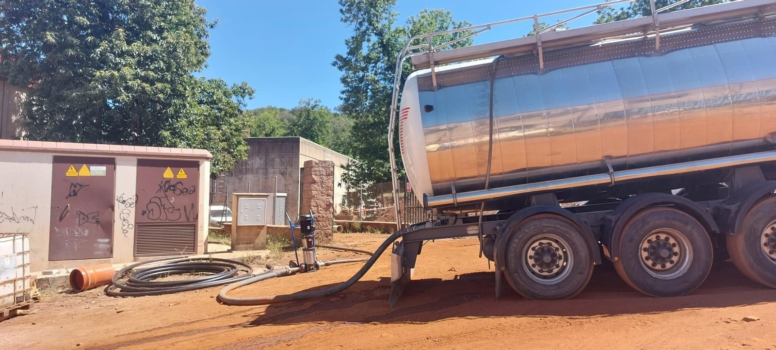 Un camión cisterna bombea agua al depósito que abastece a Higuera de la Sierra.