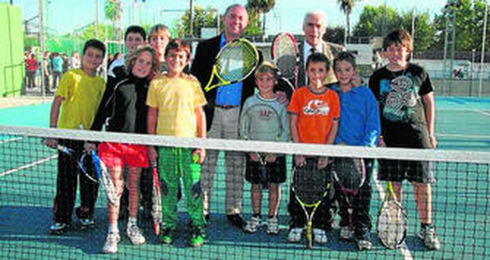 El consejero y el alcalde de Gines con un grupo de alumnos de tenis.