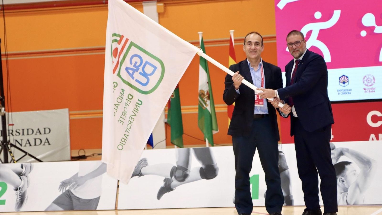 Entrega de la bandera del GADU (Grupo Andaluz de Deporte Universitario) al representante de la UAL, Pablo Martínez, para la organización de la próxima edición de los CAU.
