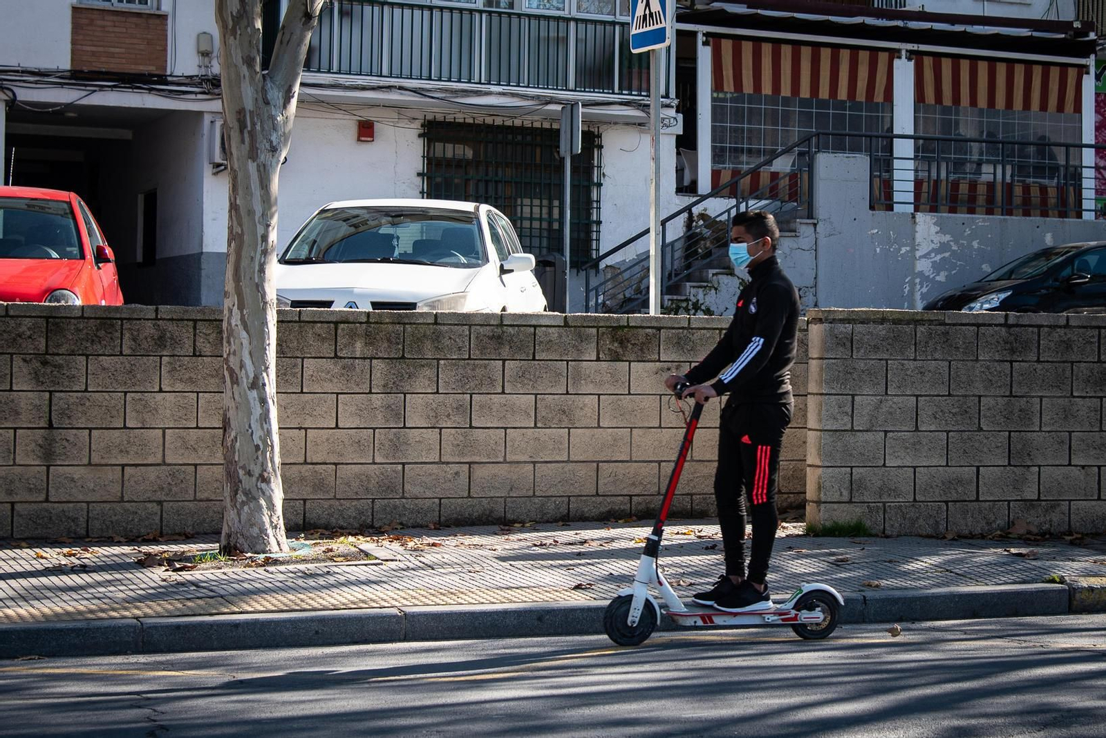Un usuario de patinete eléctrico conduce correctamente por la calzada