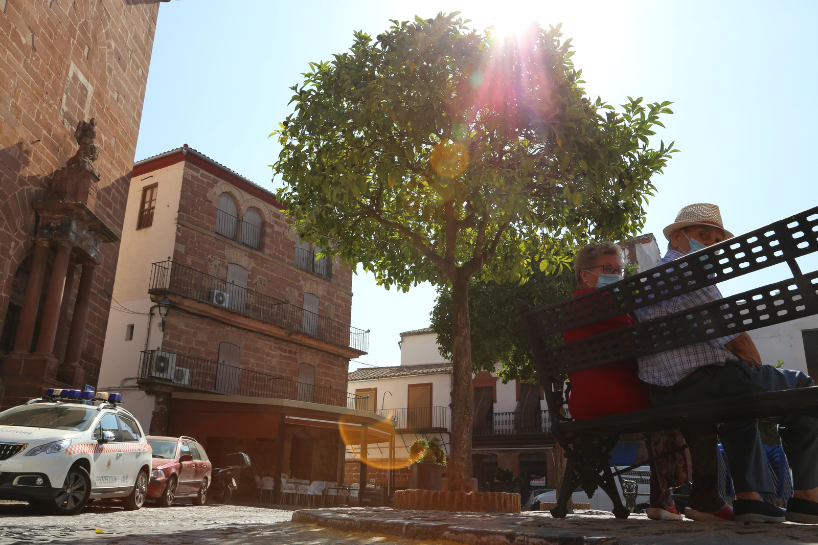 Unos jubilados, en la plaza de España de Montoro a mediodía.