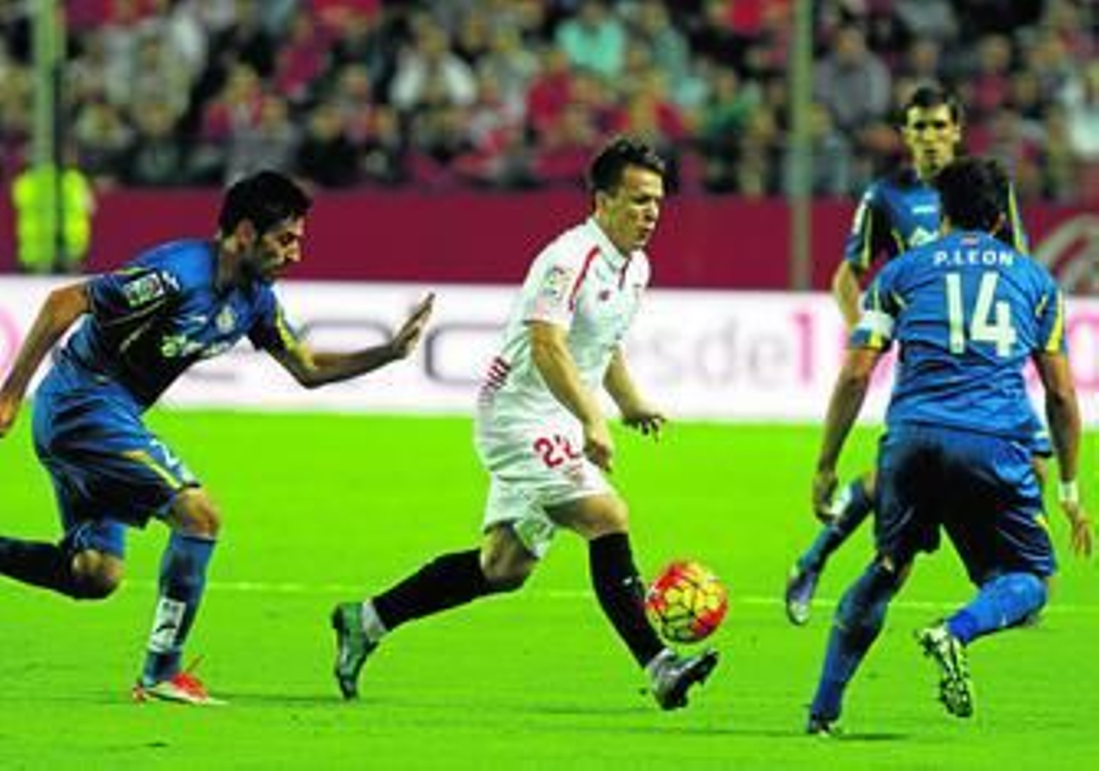 Konoplyanka ensaya un pase con el exterior de su pie derecho ante el acoso de Juan Rodríguez y Pedro León.