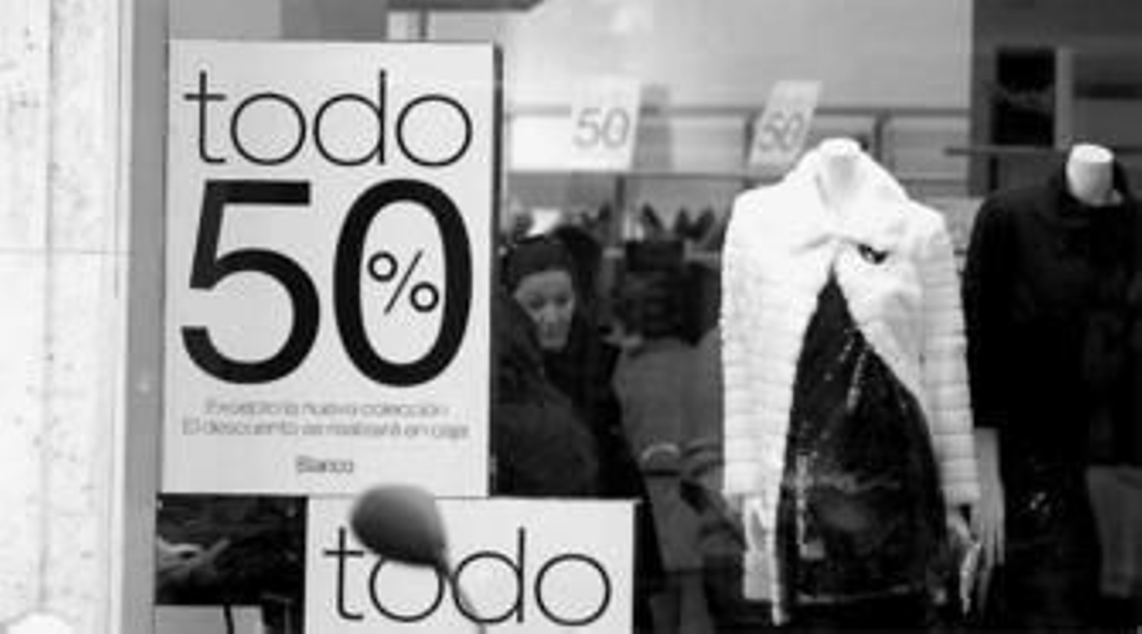 Cartel de oferta colgado en una tienda de ropa del centro de la capital. Cartel de oferta colgado en una tienda de ropa del centro de la capital.