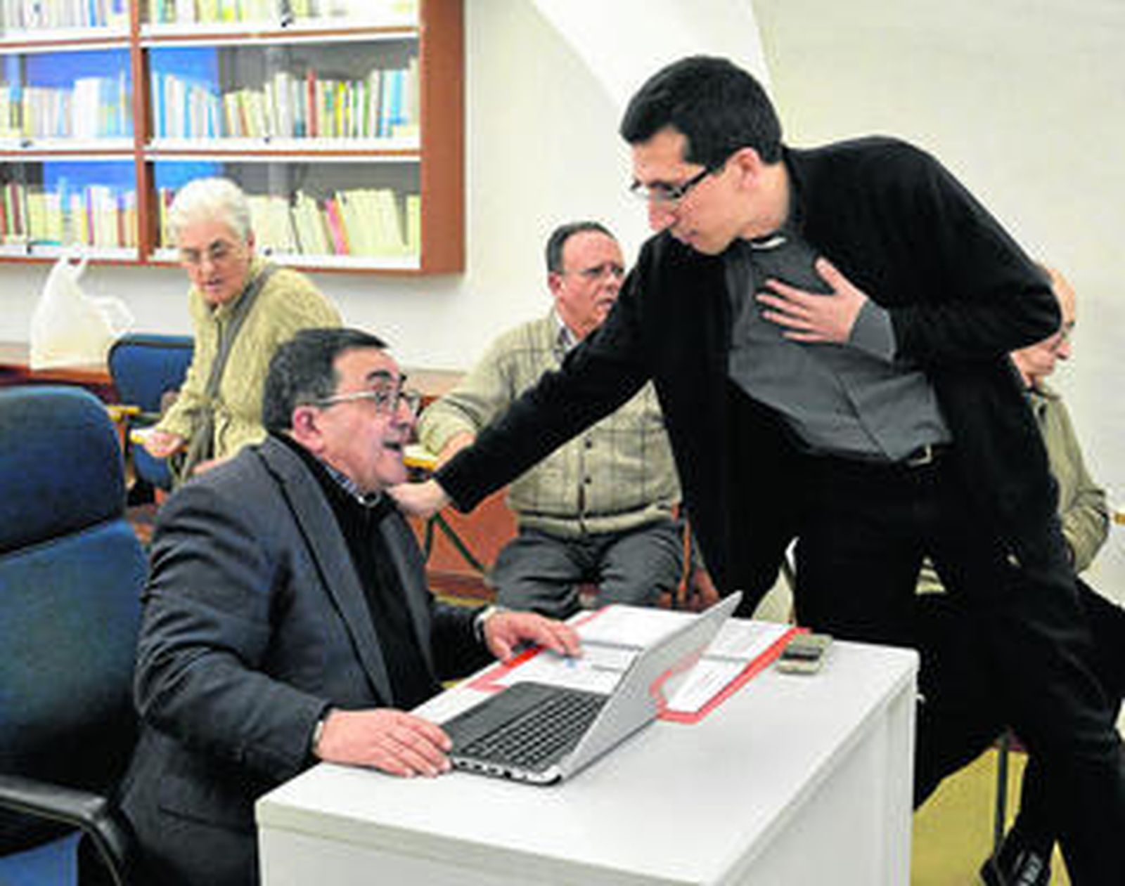 El director de formación de Cáritas, Nicolás Martínez, dialoga con el director del Sarus, Álvaro Pereira (de pie).