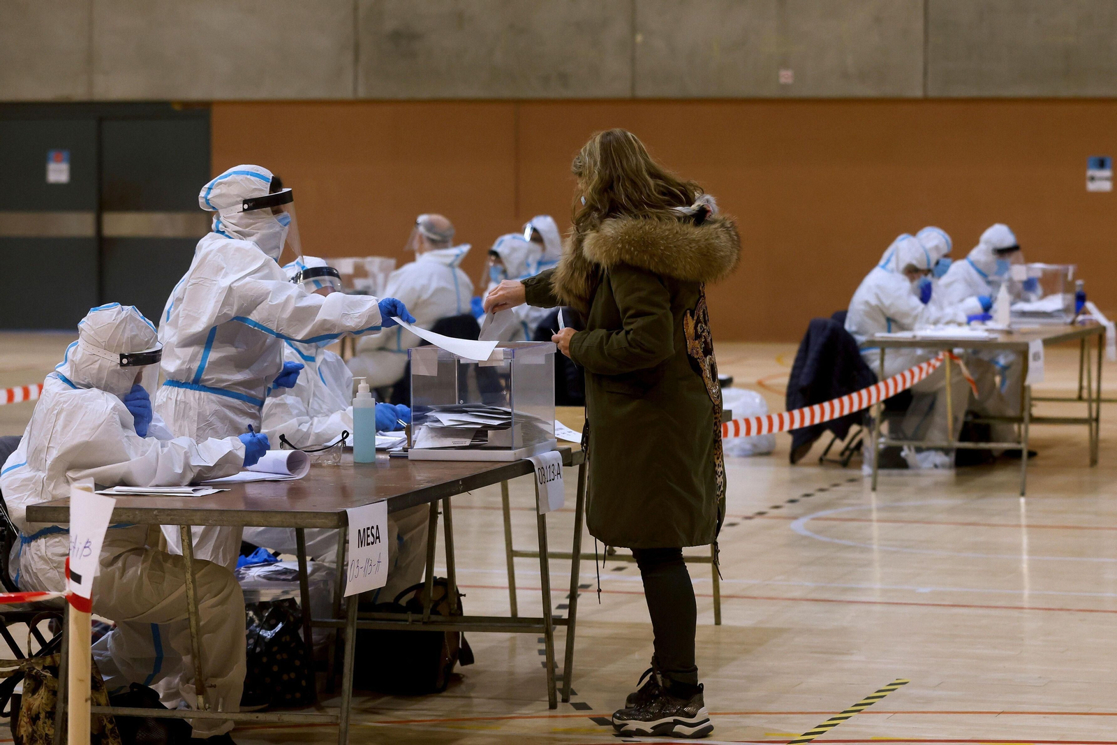 Integrantes de las mesas de votación equipadas con equipos de protección individual (EPI), en el Polideportivo Municipal de la España Industrial de Barcelona.