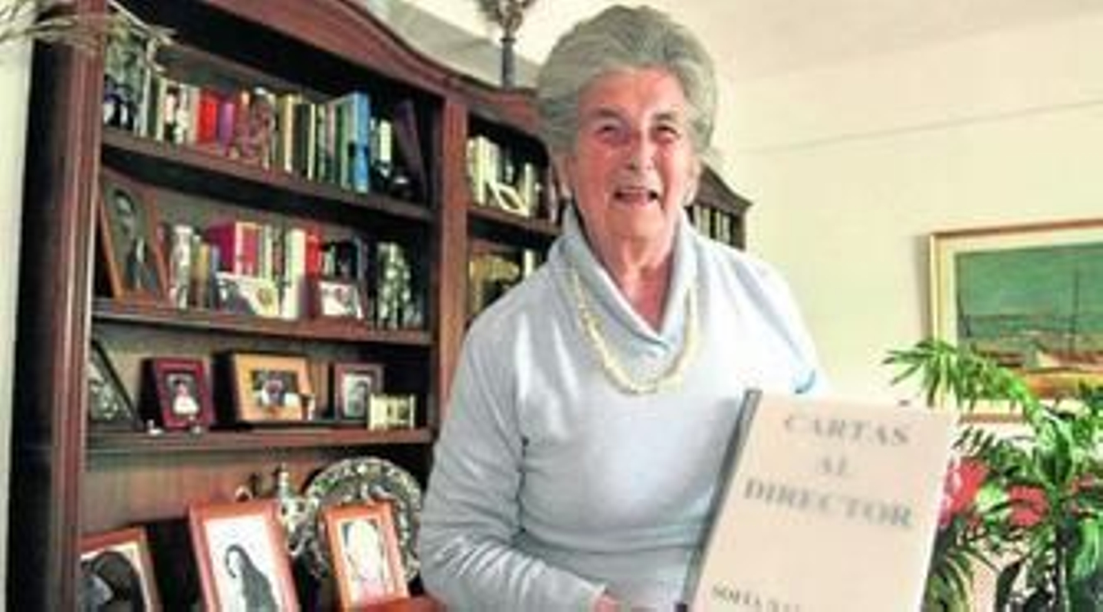 Sofía Navarrete, ayer en su piso, muestra las notas encuadernadas. Sobre estas líneas, escribiendo en un cuaderno.