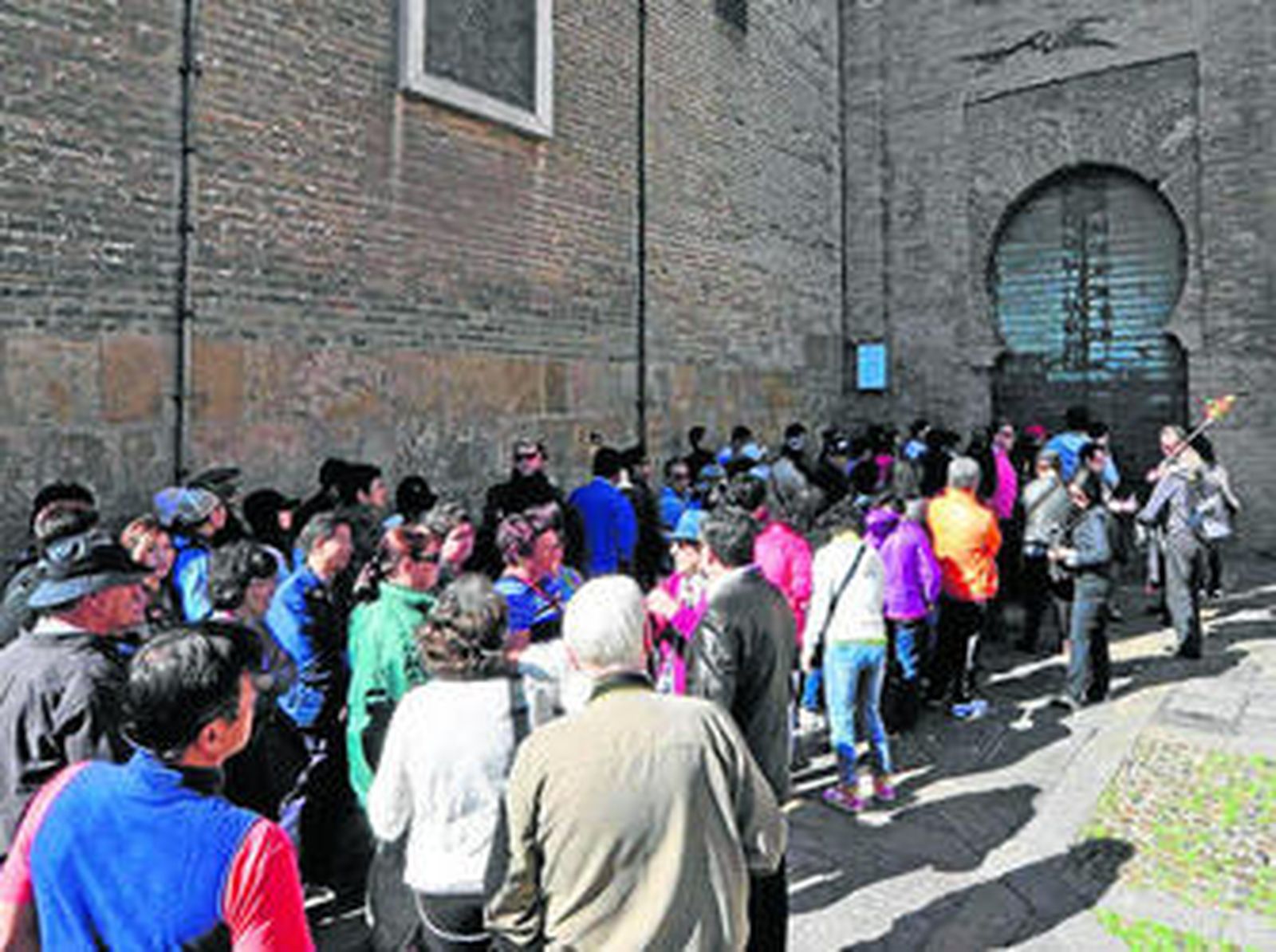 Un grupo de turistas hace cola para acceder a la Catedral por la conocida Puerta del Lagarto.