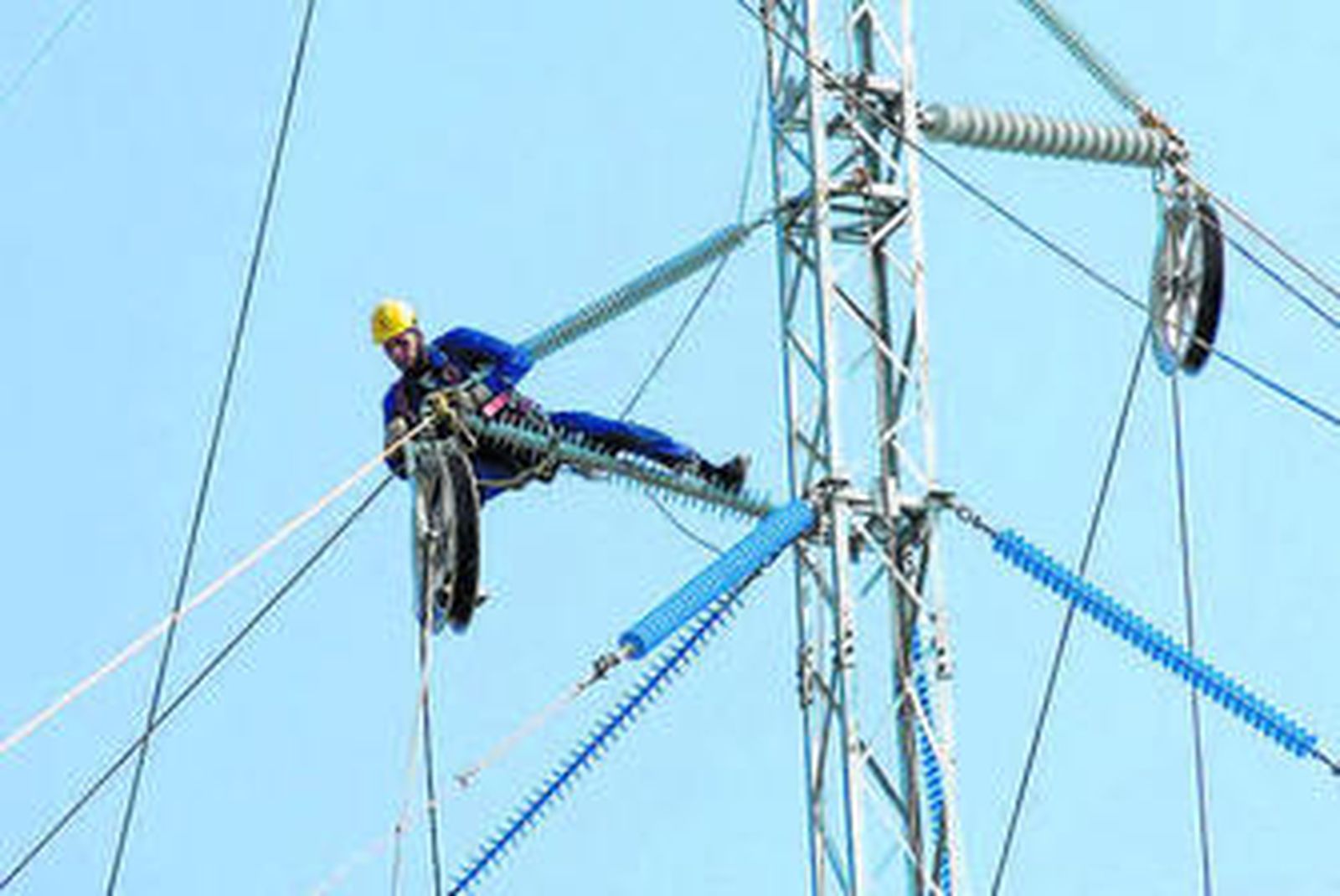Un operario trabaja sobre un poste de electricidad.