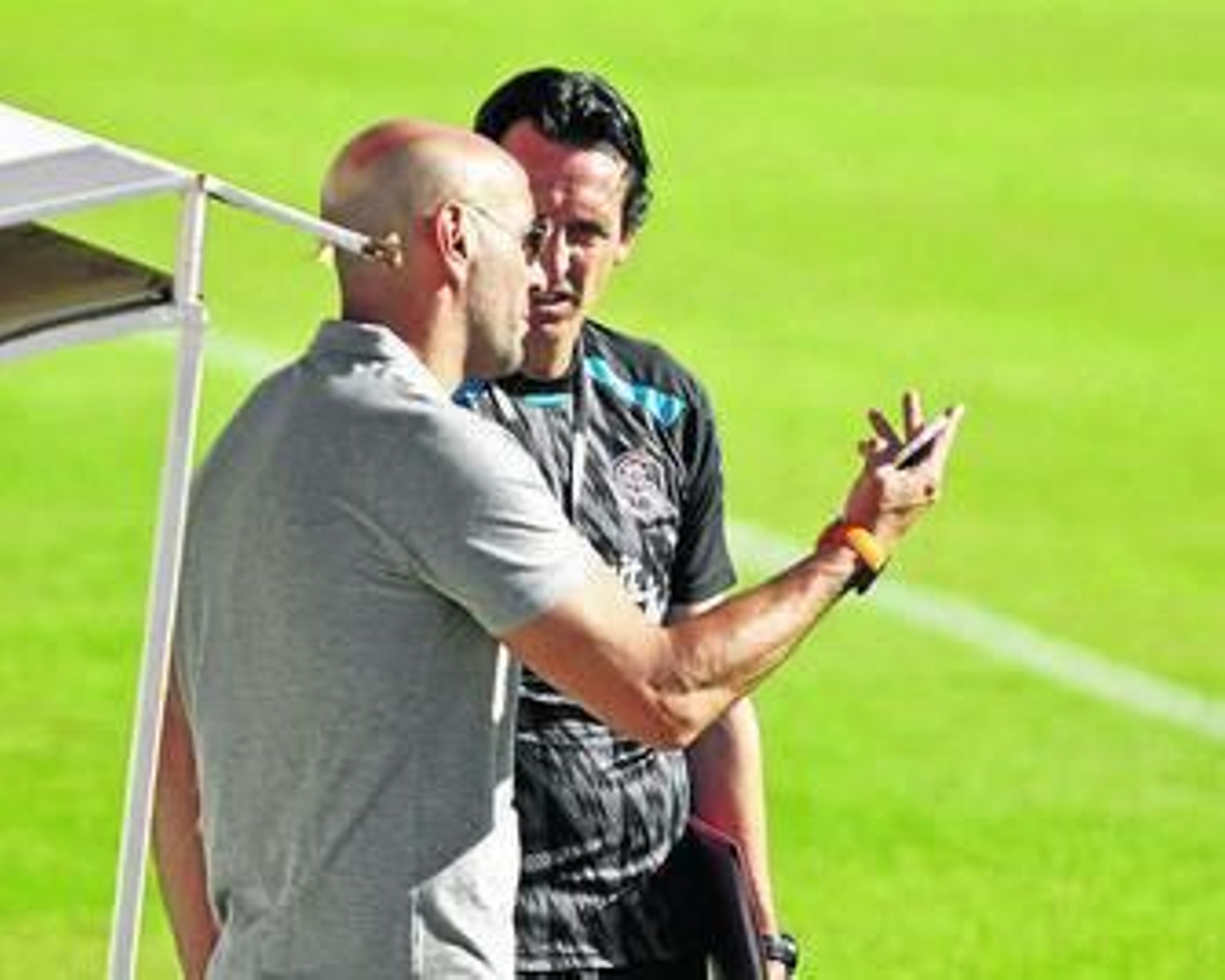 Monchi charla con Unai Emery en un receso de un entrenamiento.