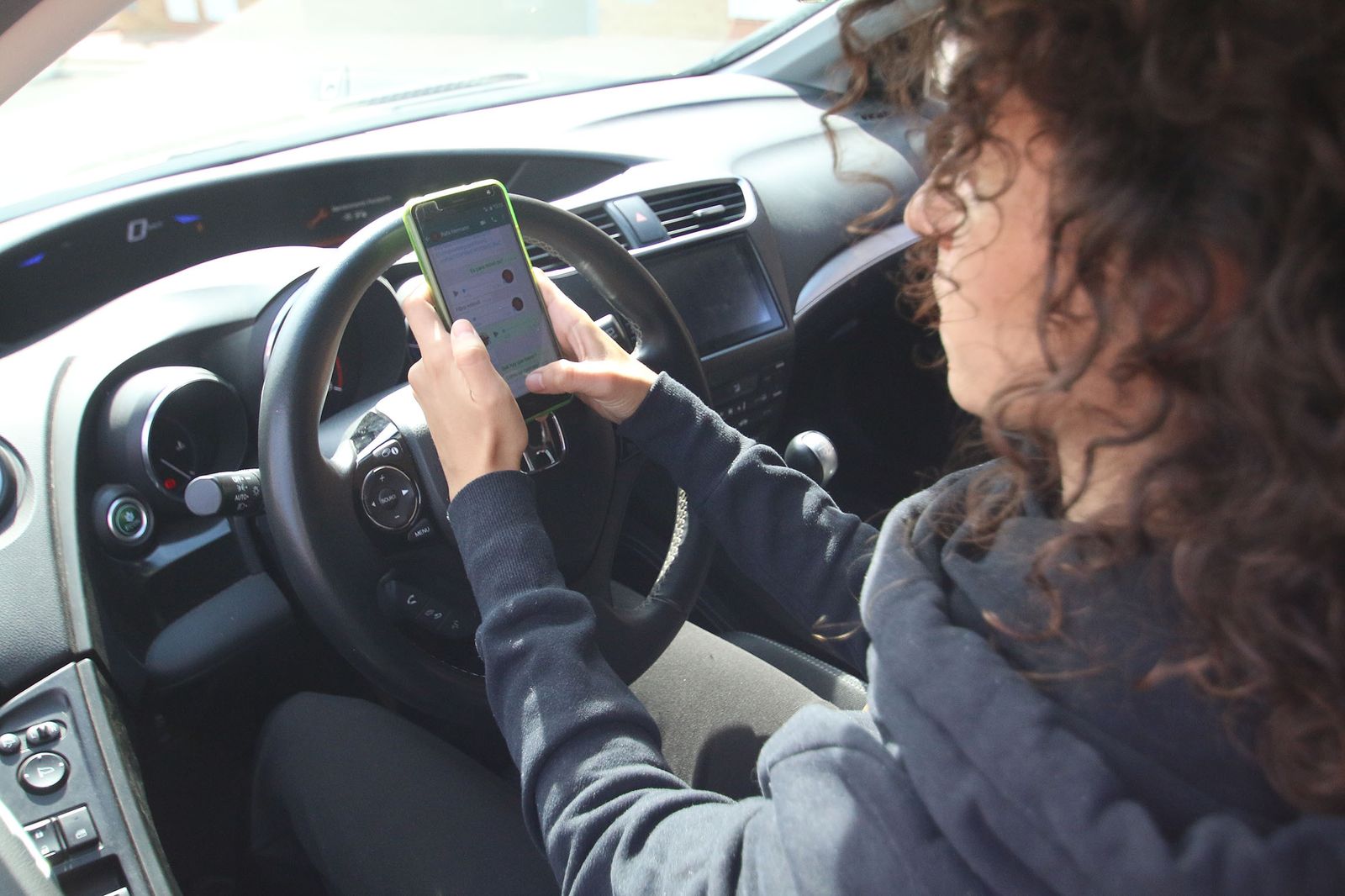 Una mujer escribe por Whatsapp mientras está en el coche
