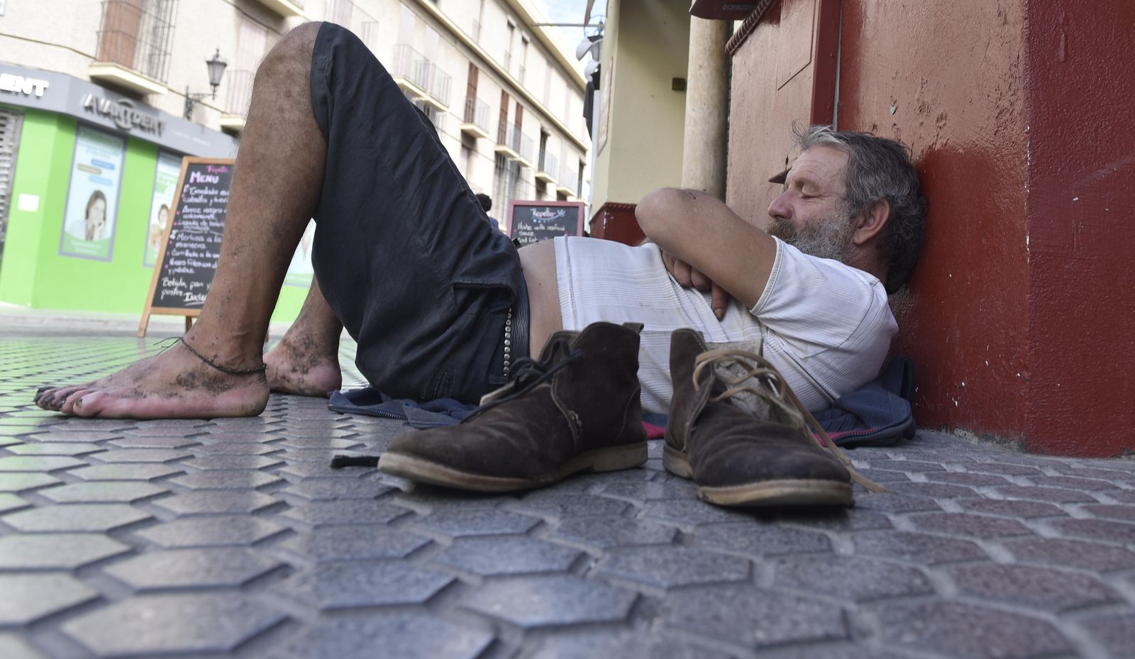 Un hombre duerme en el suelo en plena calle.