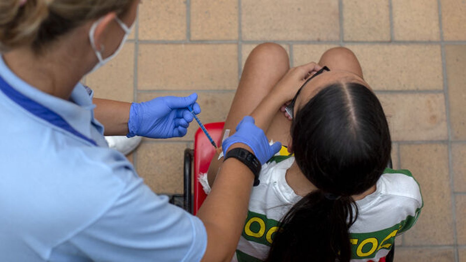 Un sanitario le pone una dosis de la vacuna a una niña en Cádiz.
