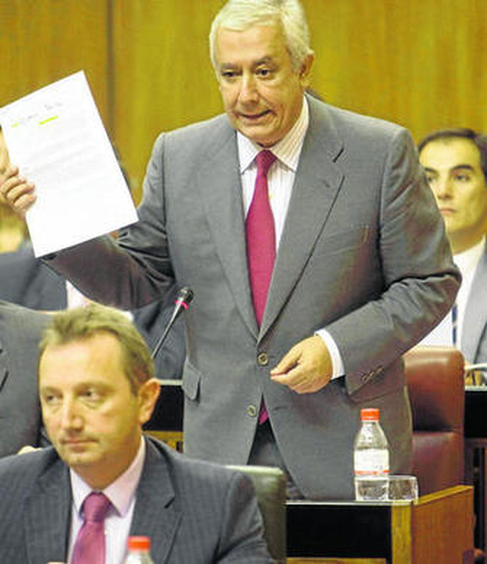 El consejero de Empleo, Manuel Recio, escucha a Javier Arenas ayer en el Parlamento.