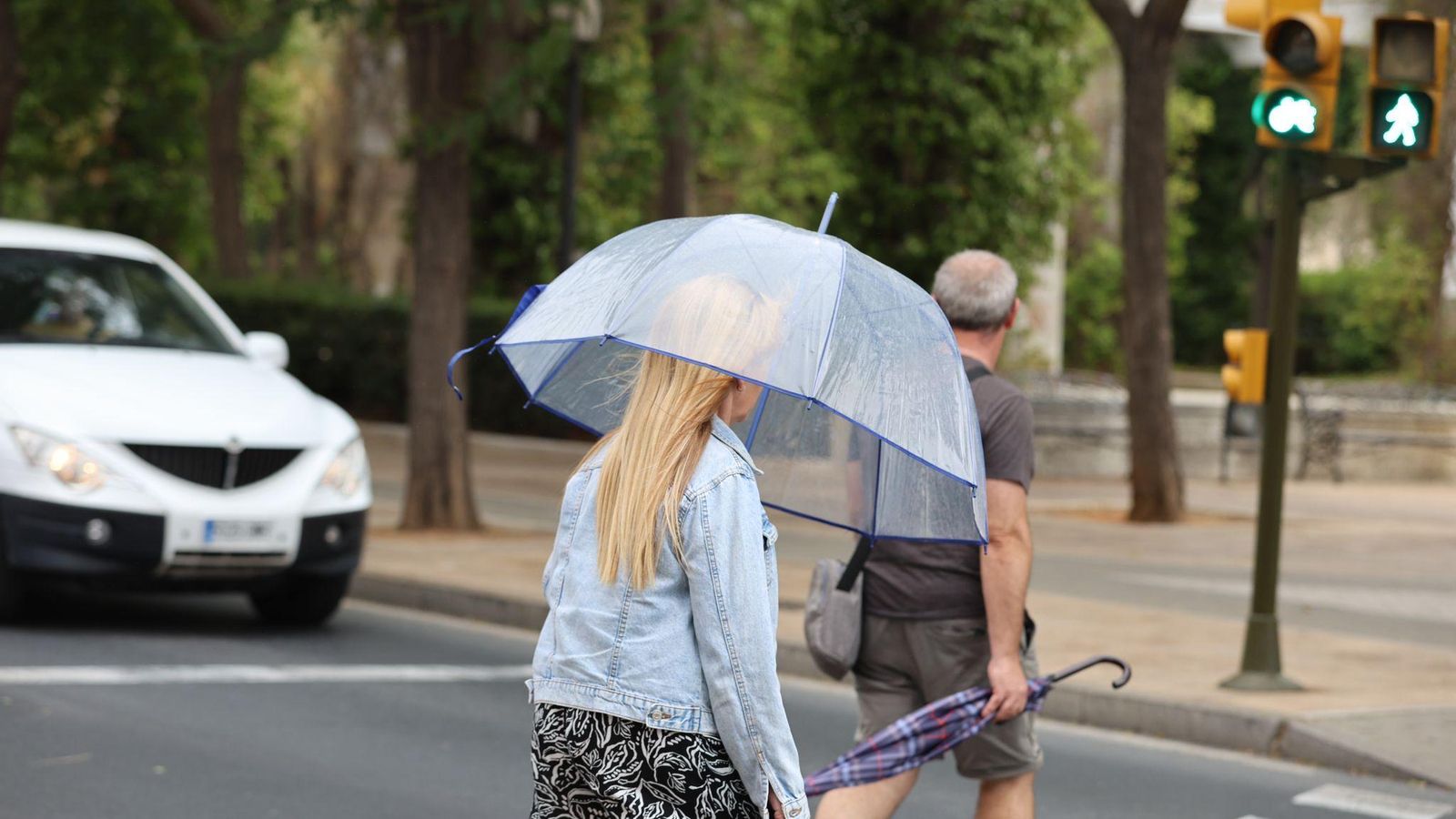 Una mujer por las calles de Huelva protegiéndose de la lluvia con un paraguas.