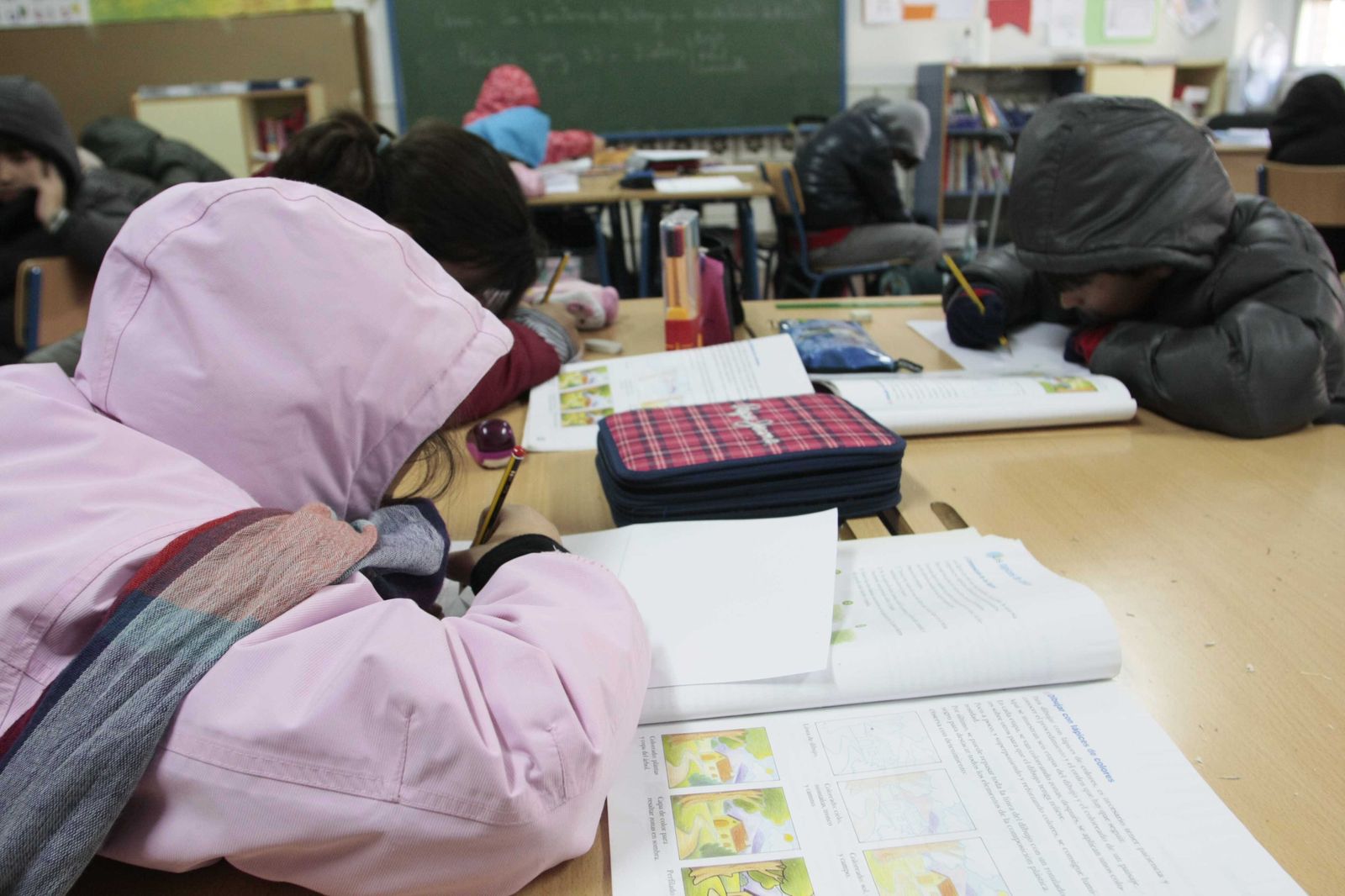 Alumnos con abrigos en el aula de un colegio por la falta de calefacción.