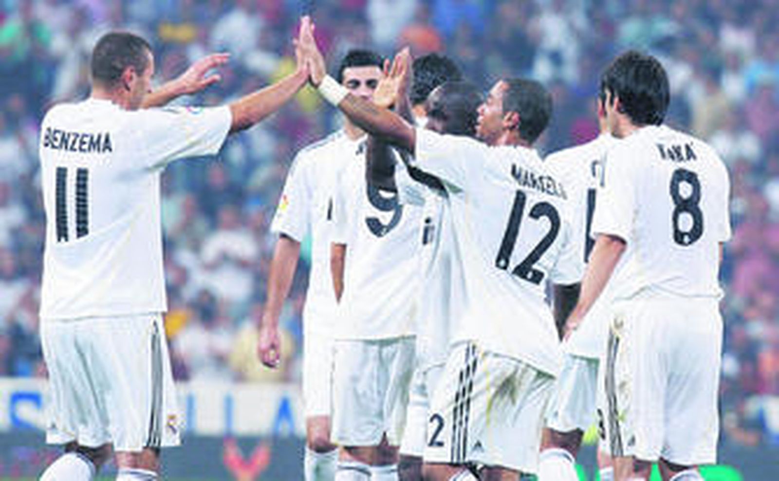 Los jugadores del Real Madrid felicitan a su compañero Lass tras conseguir el gol de la victoria de los blancos.