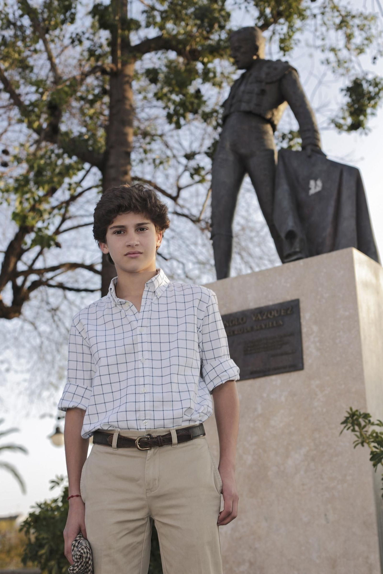 El futuro matador, siendo casi un niño aún, delante del monumento de su abuelo Manolo Vázquez.