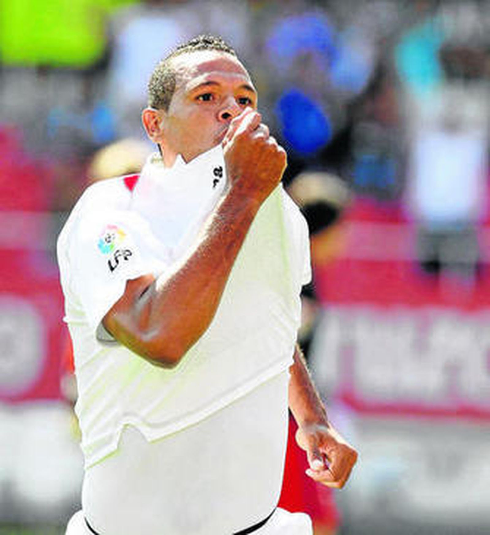 Luis Fabiano besa el escudó del Sevilla tras marcar el 1-0.