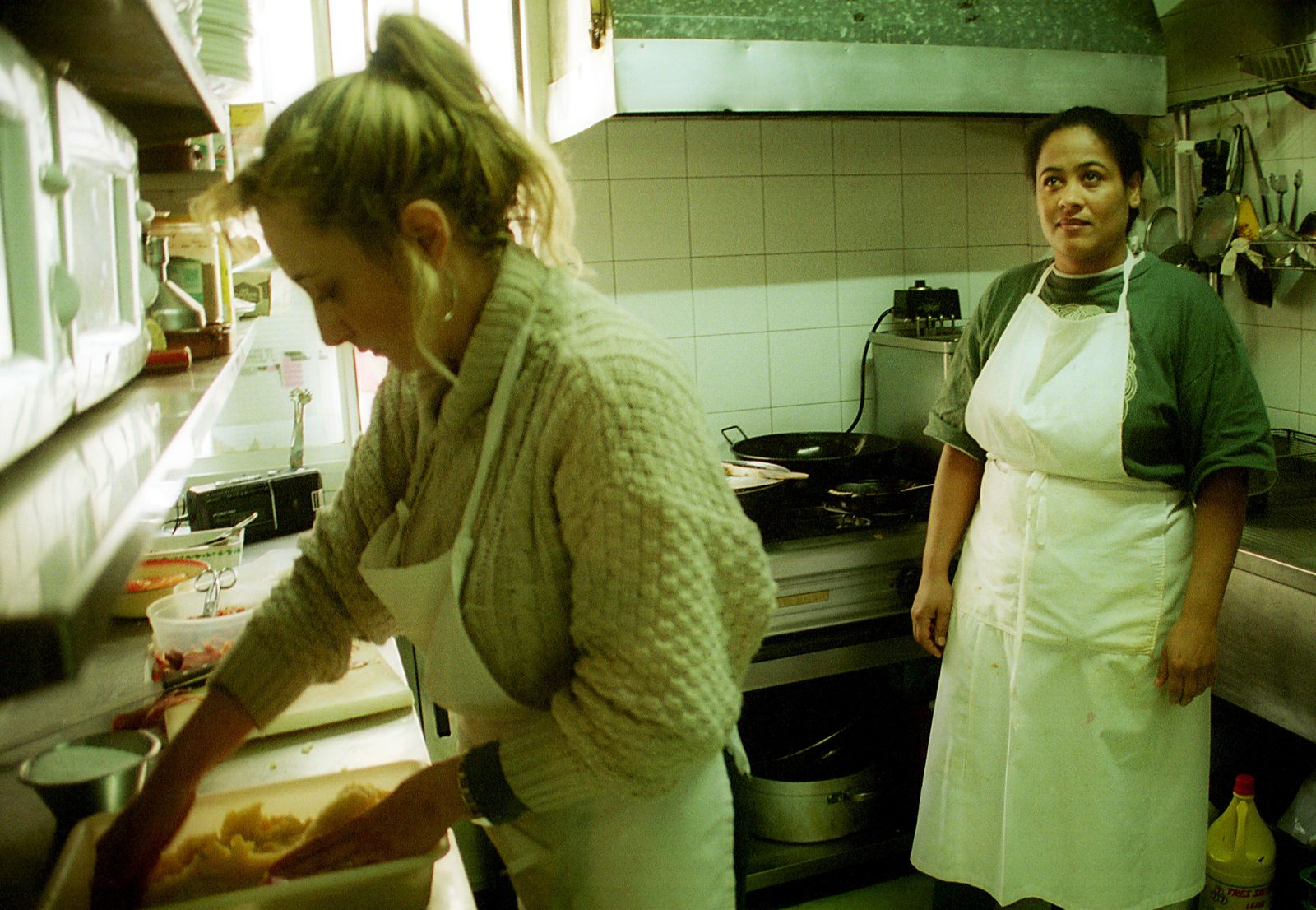 Mujeres migrantes trabajando en una cocina.