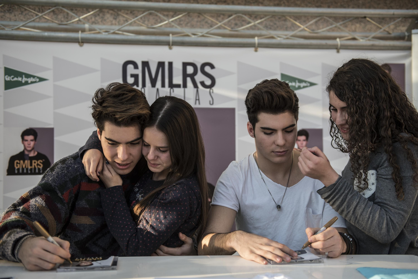 Jesús y Dani durante un momento de la rubrica de los discos mientras sus fans los abrazan y besan.