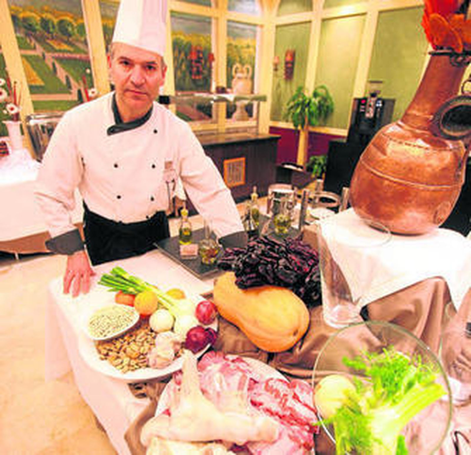 El chef del Hotel Granada Center, Juan Pedro Campos, junto con los ingredientes de la olla de San Antón.