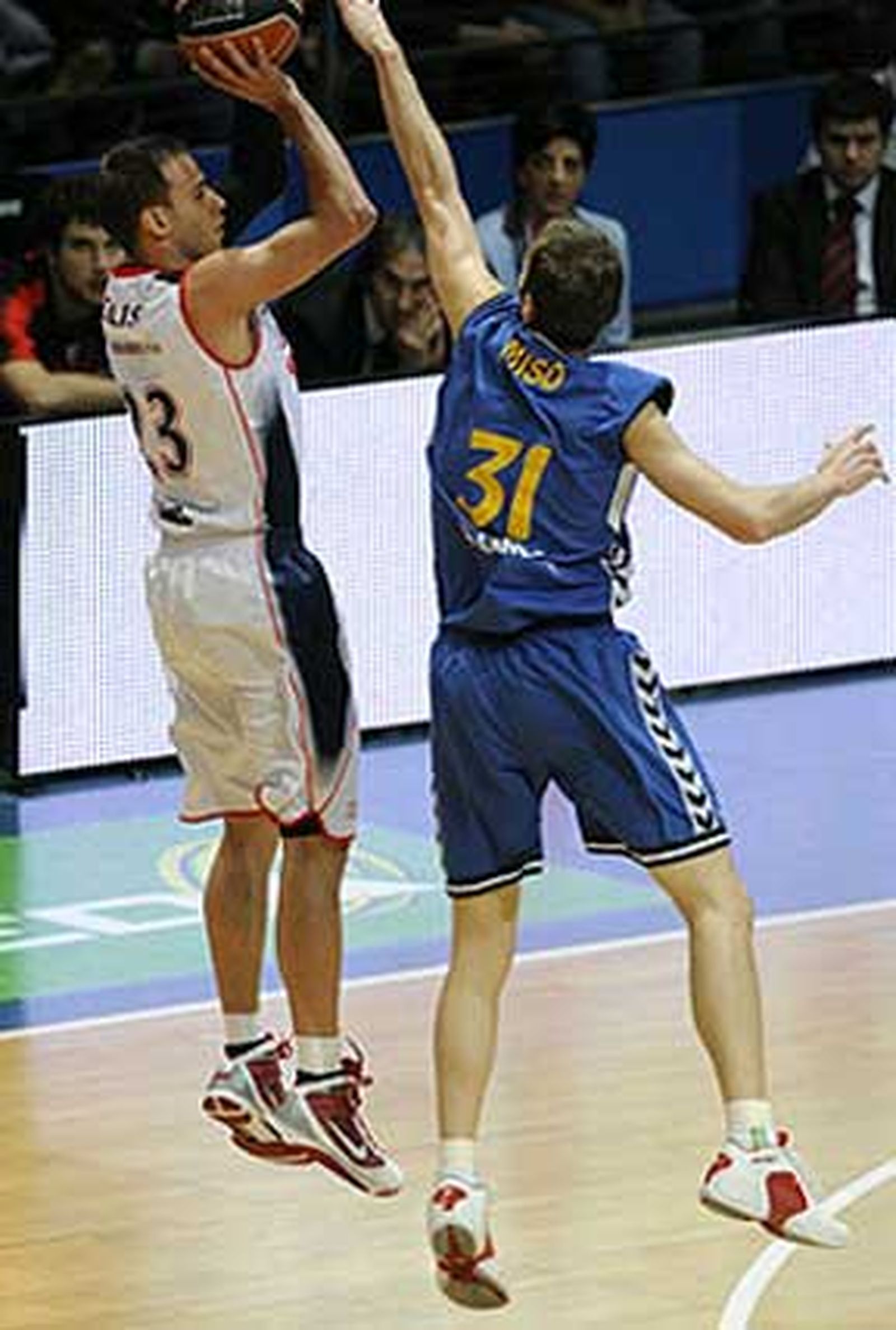 Andres Miso puntea el lanzamiento triple del jugador local Carl English.

Foto: ACB Photo / L. González