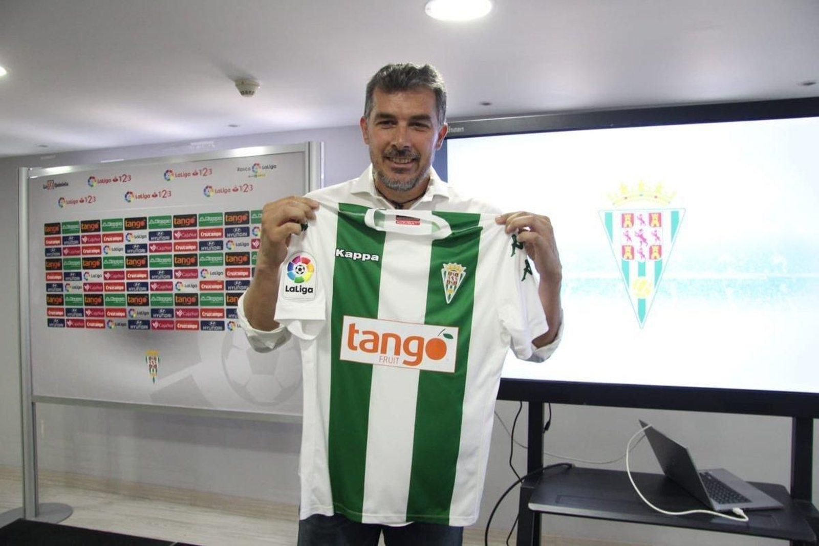 Juan Marrero, nuevo técnico del Córdoba B, posan con la camiseta blanquiverde del club.