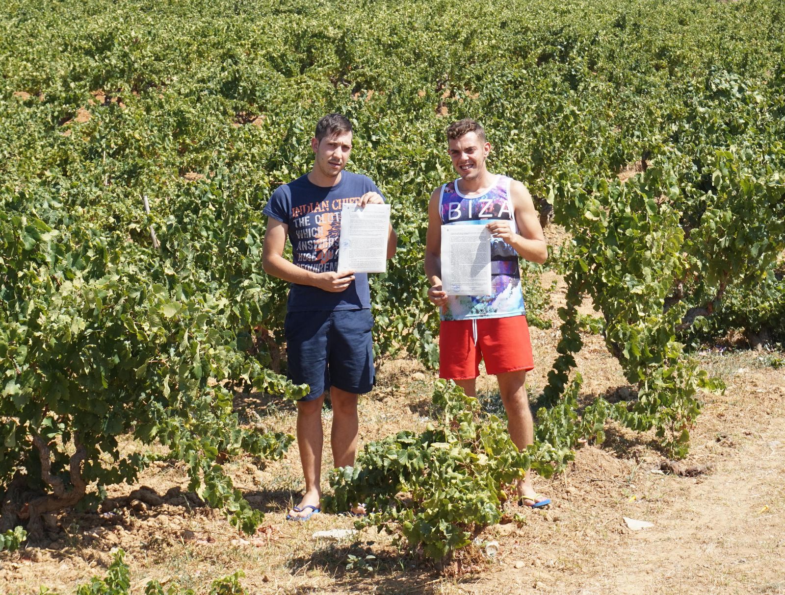 Dos de los afectados rocianeros, Sergio Orihuela y Juan Antonio Suárez, posan entre vides con sus denuncias.