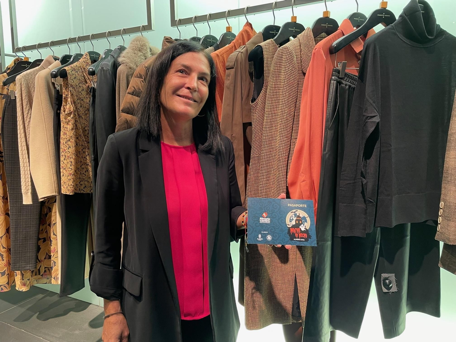 La gerente de Almería Centro muestra el pasaporte de la Noche en Negro