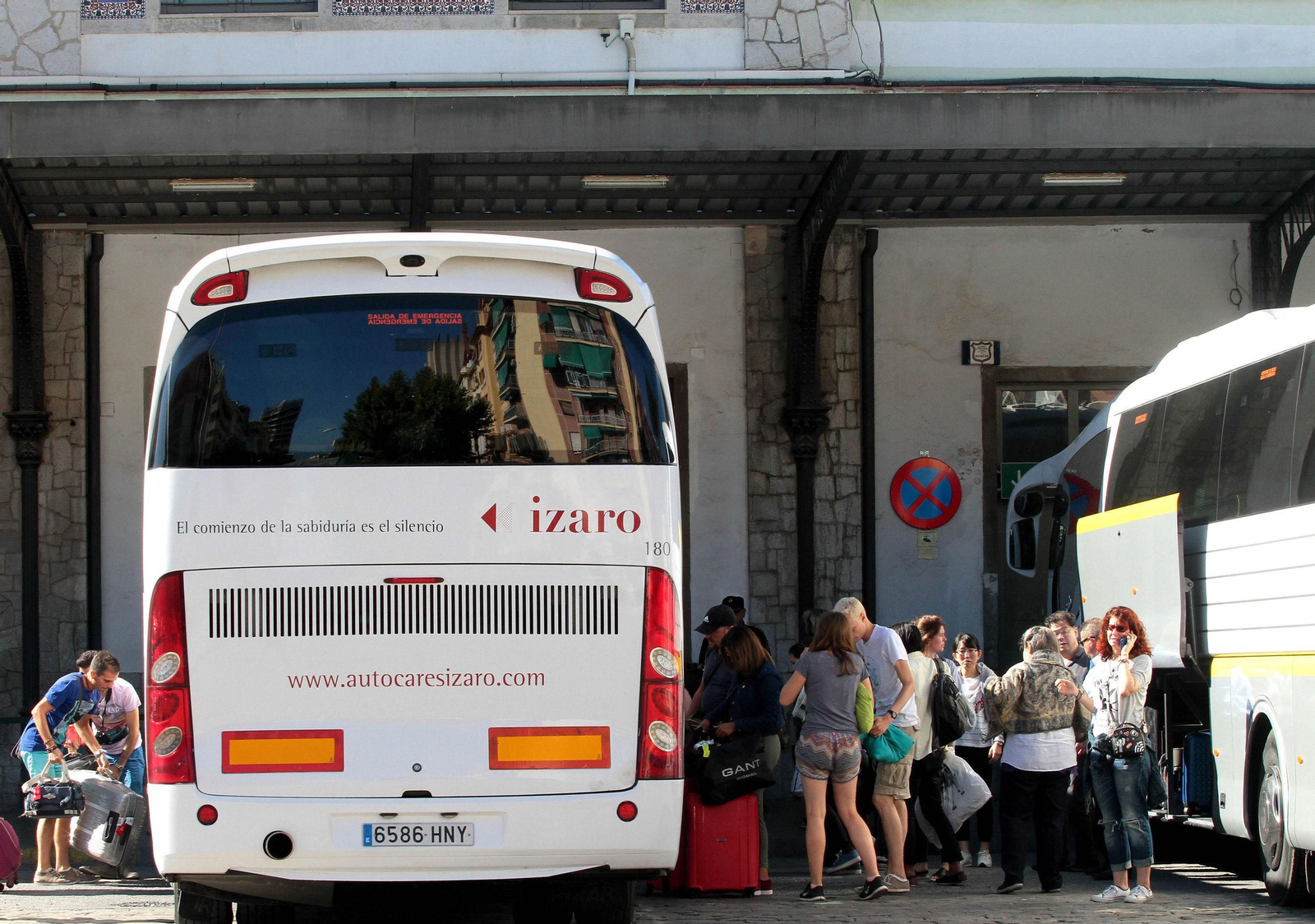Viajeros toman el autobús frente a la estación de tren de Granada.