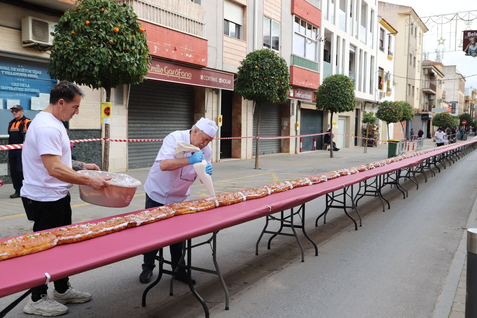Uno de los pasteleros rematando el roscón