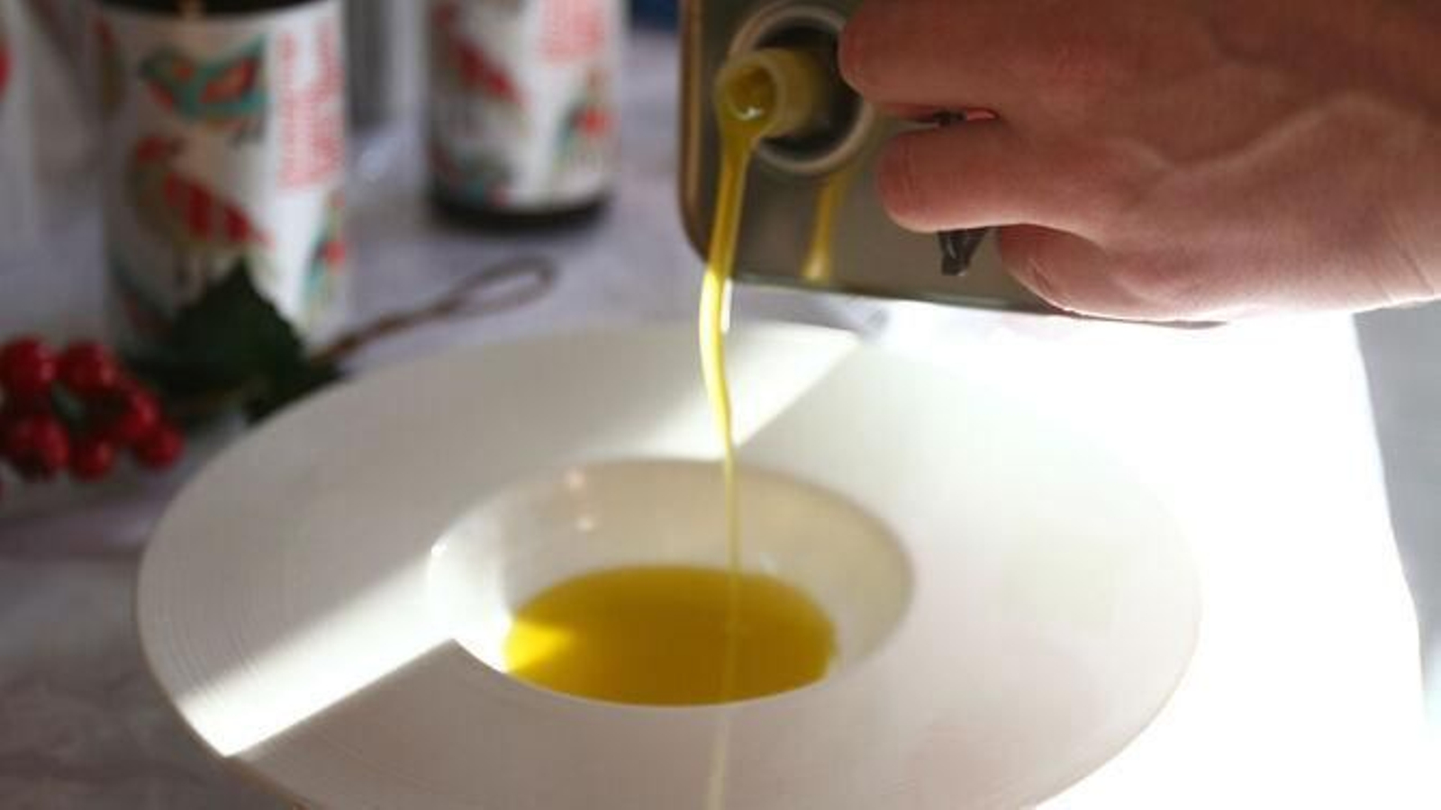 Una persona pone aceite de oliva en un plato para degustar Una persona pone aceite de oliva en un plato para degustar