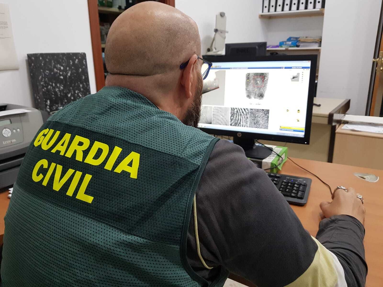 Un agente coteja huellas en el laboratorio de Criminalística.