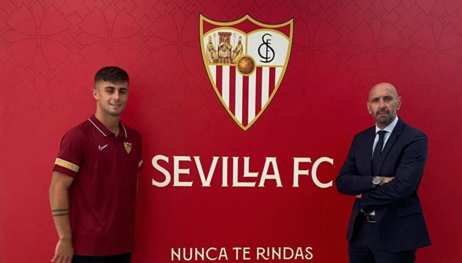 David Santisteban posa con Monchi ante el escudo del Sevilla.