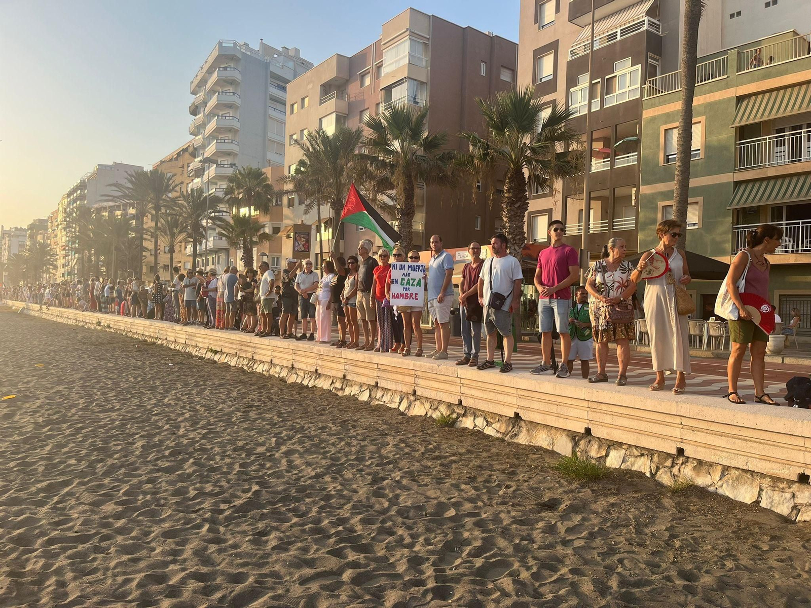 Cadena humana sobre el muro blanco del Paseo Marítimo