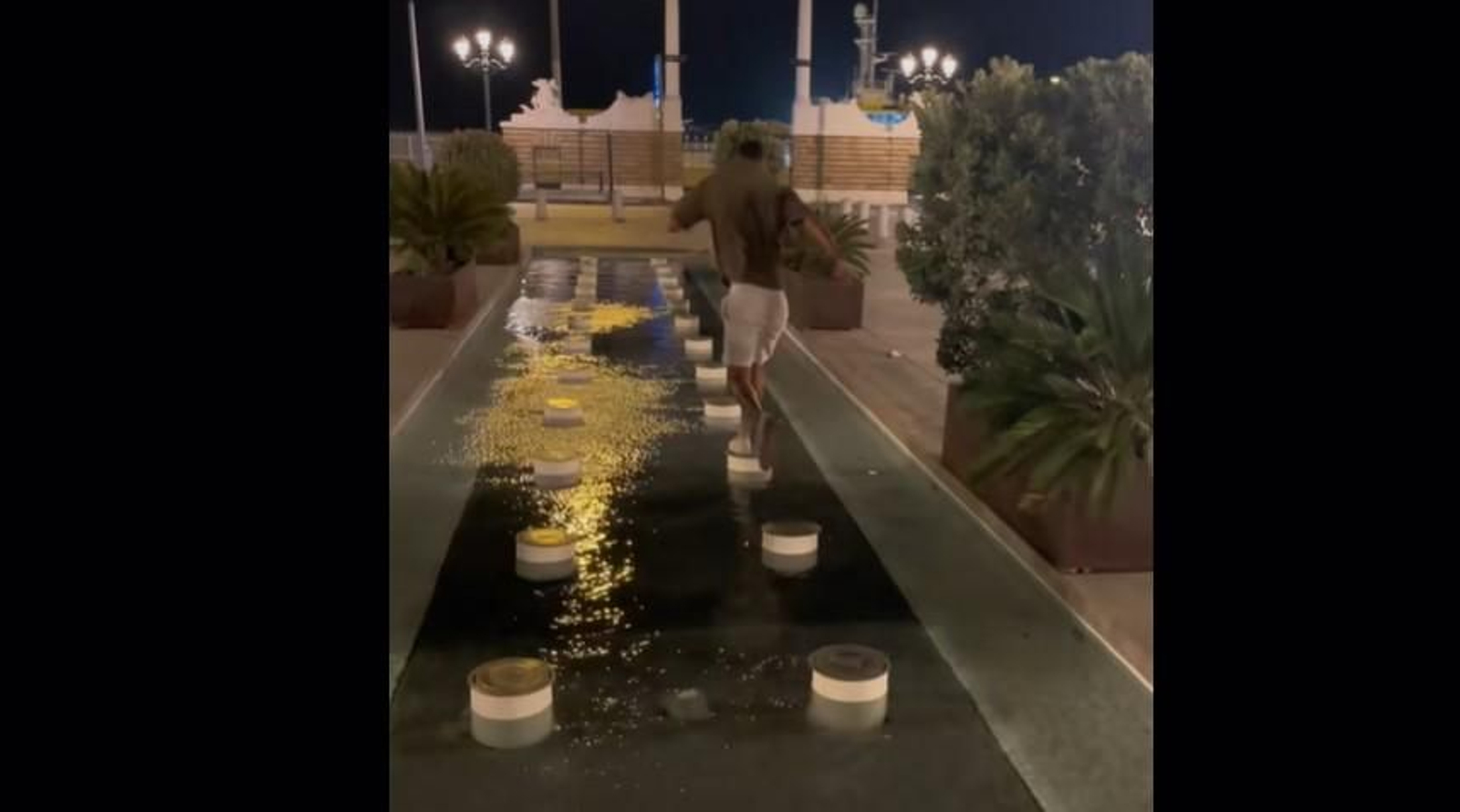 Un turista salta sobre una fuente en Cádiz