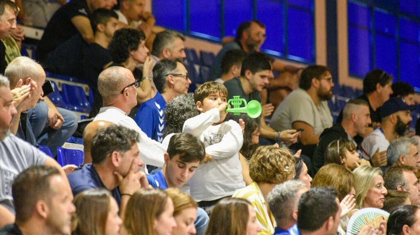 Un joven aficionado de Udea, con una trompeta de juguete.