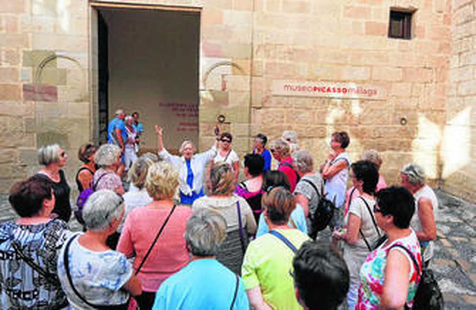 Un grupo de turistas escucha a su guía, ayer, frente a la puerta del Museo Picasso.