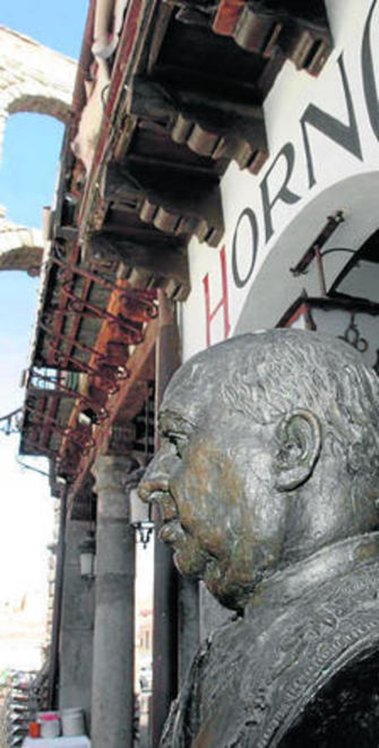 Primer plano de un busto de Cándido en la puerta del restaurante.