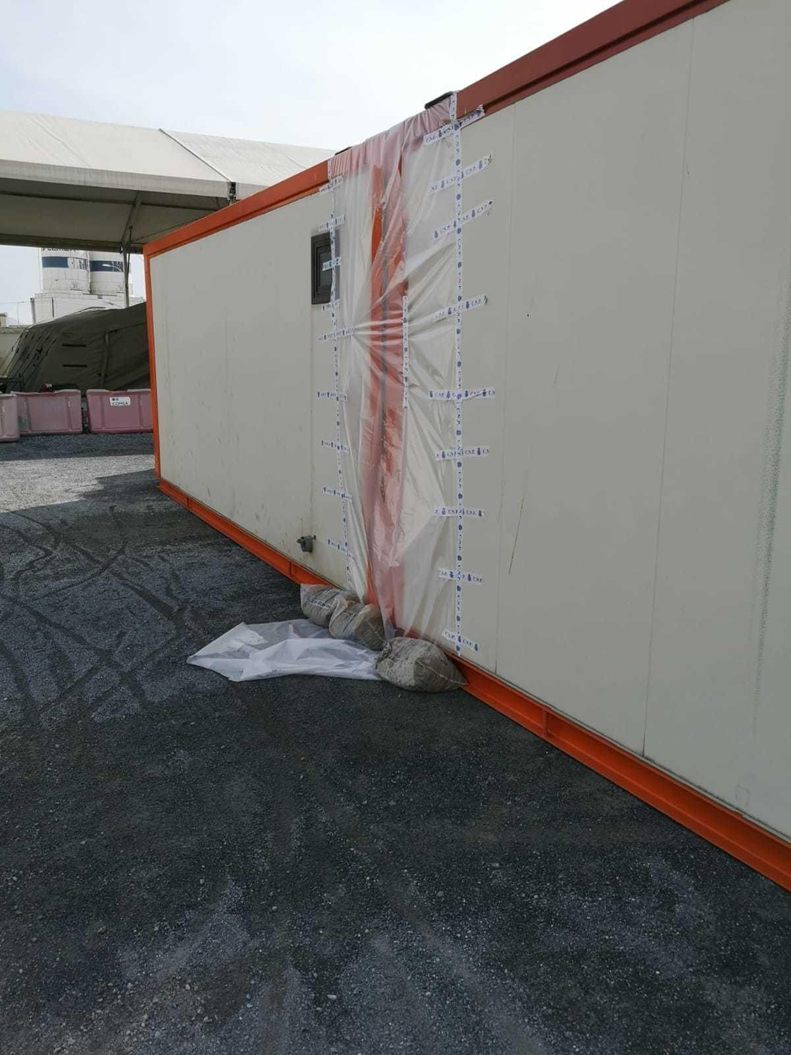 Se están colocando plásticos entre los módulos de inmigrantes como protección por si llueven mientras se instalan