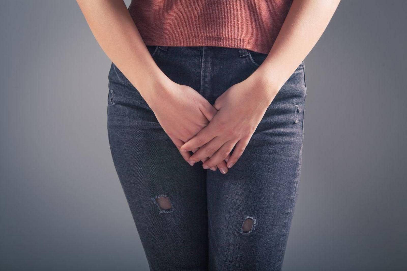 Una mujer joven se cubre con sus manos