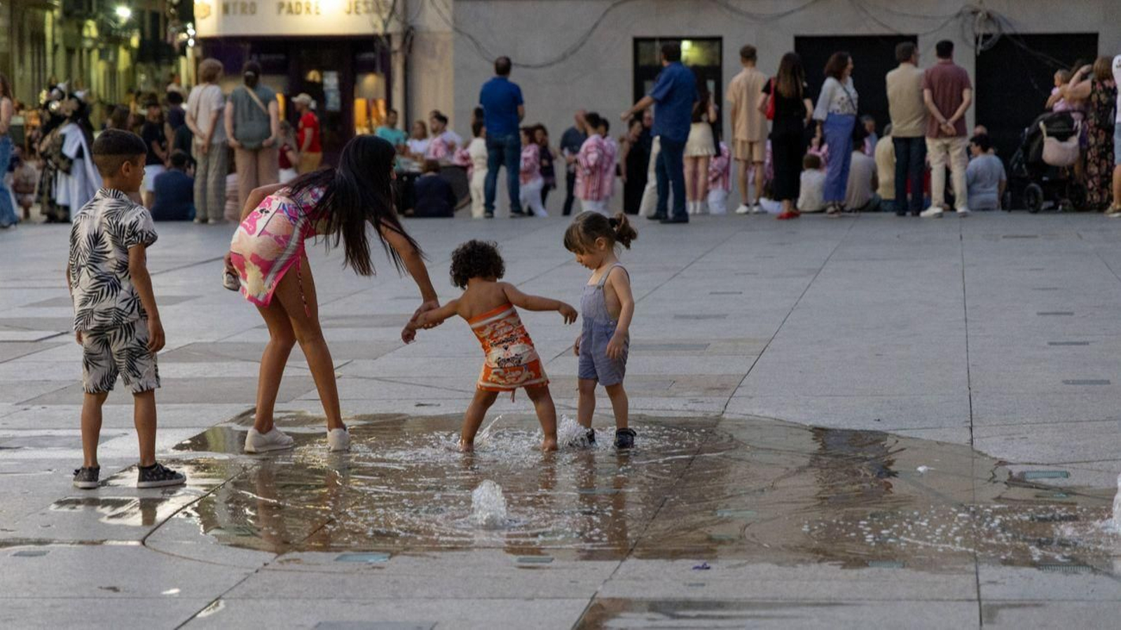 Niños disfrutando del agua en la plaza de Santa María.