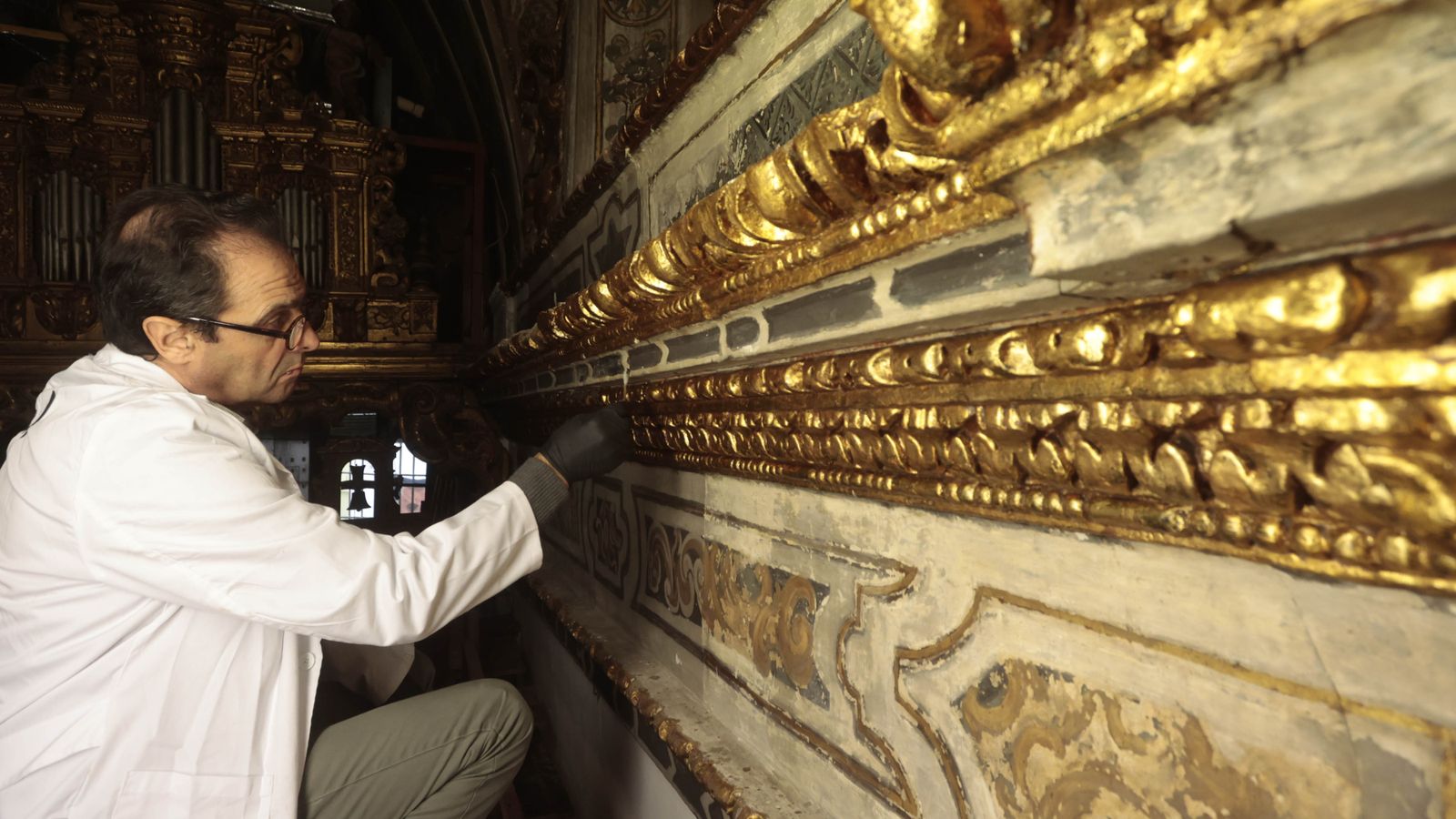 Uno de los restauradores trabajando en la limpieza del dorado.