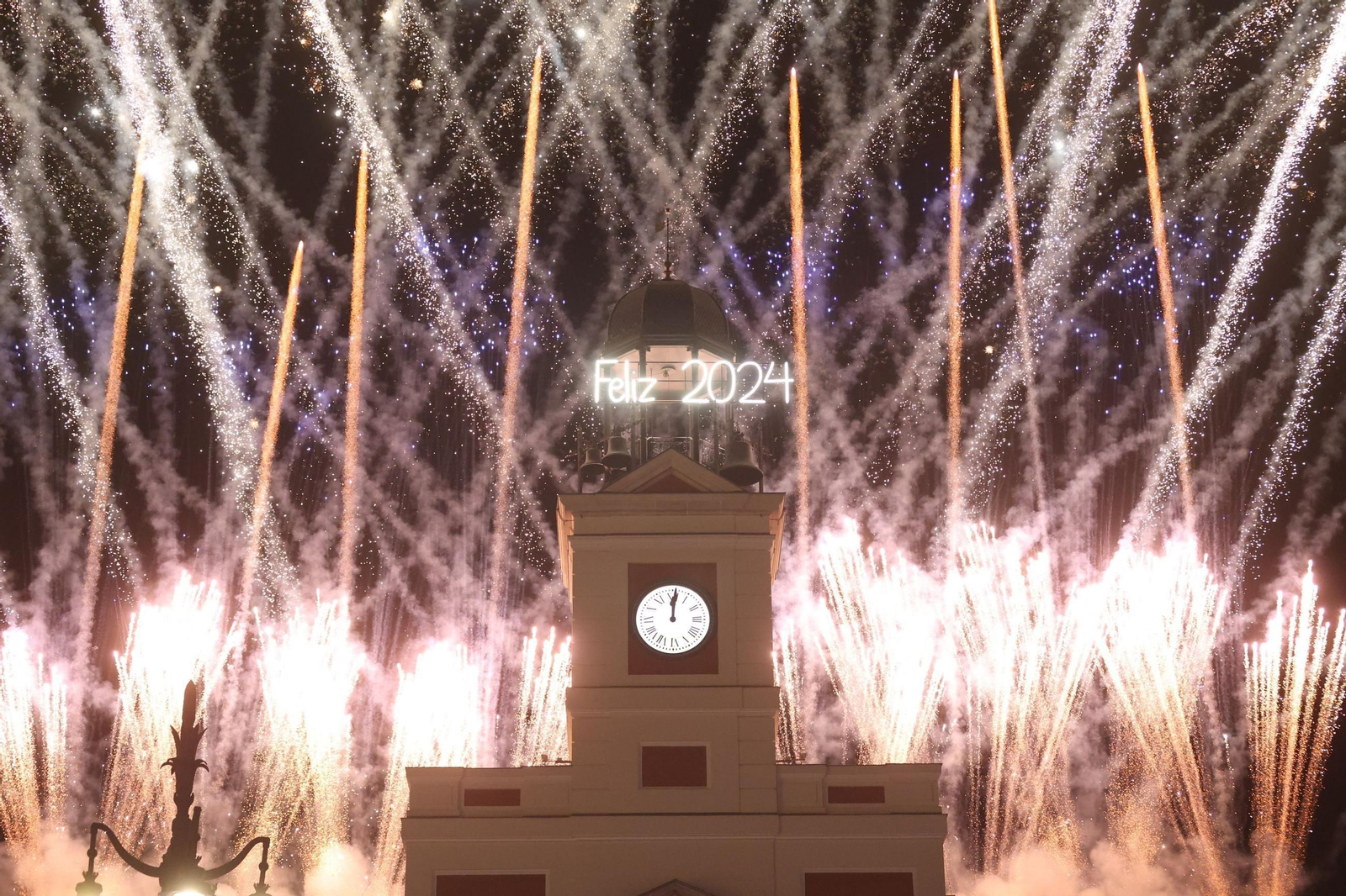 El reloj de la Real Casa de Correos felicita el pasado 2024 con fuegos artificiales en la Puerta del Sol de la capital de España.