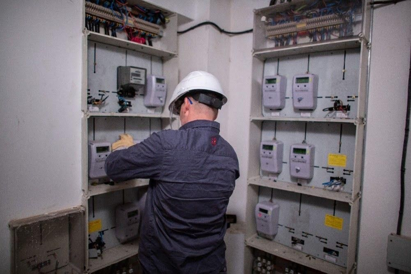 Un operario revisa varios contadores eléctricos de la luz.