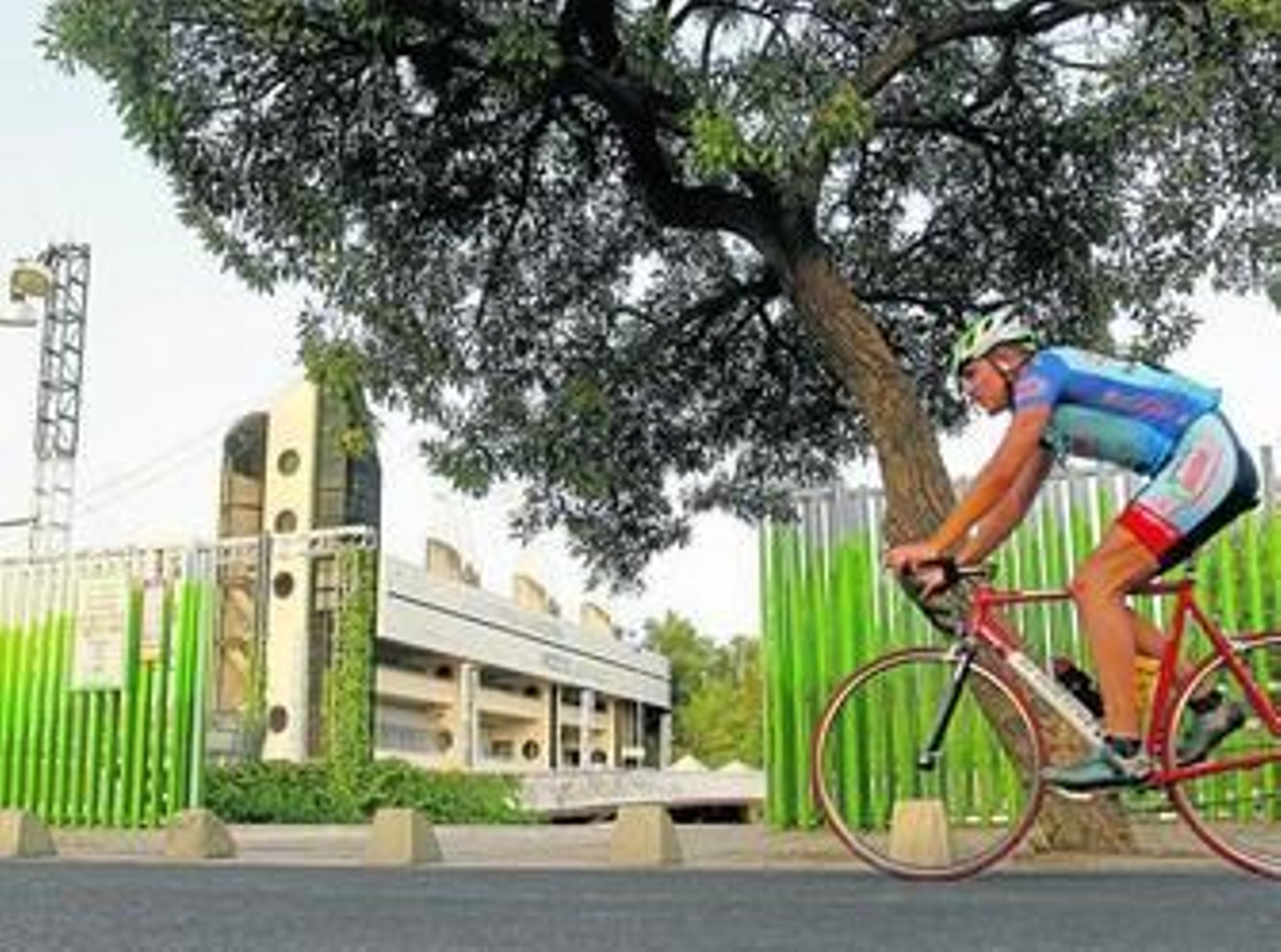Un ciclista pasa junto al auditorio Rocío Jurado, en la Isla de la Cartuja.
