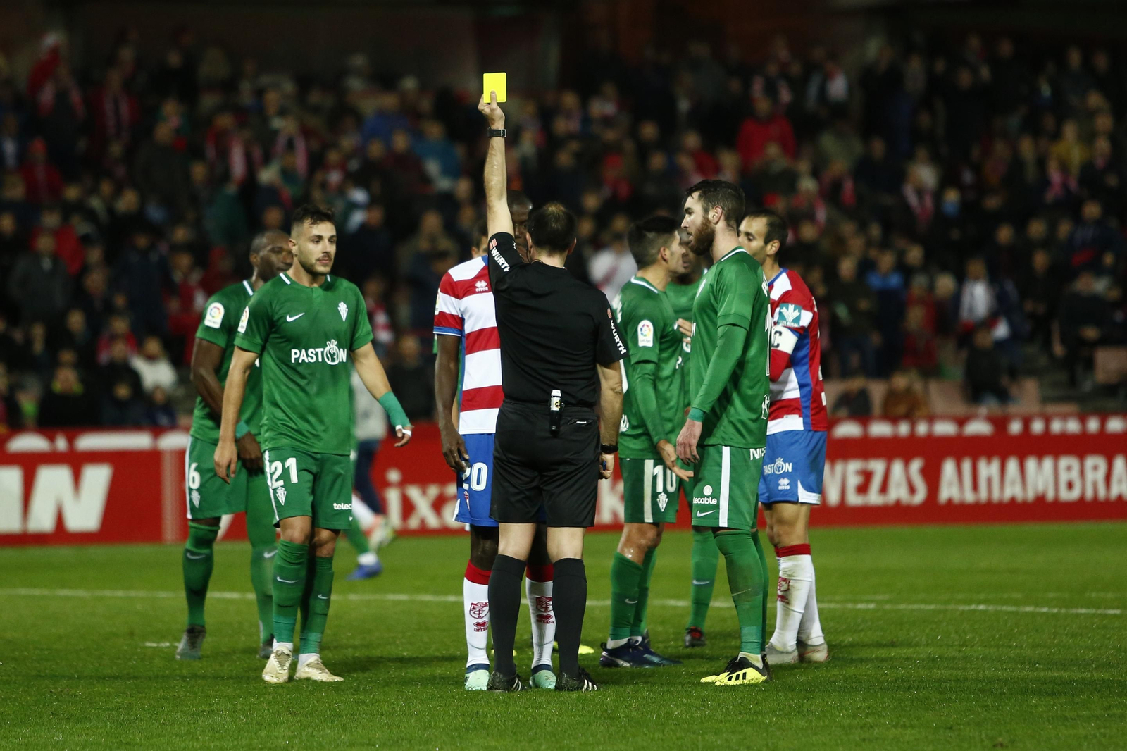 Ocón Arráiz le muestra a Adrián Ramos una amarilla en el partido del Granada CF ante el Sporting.