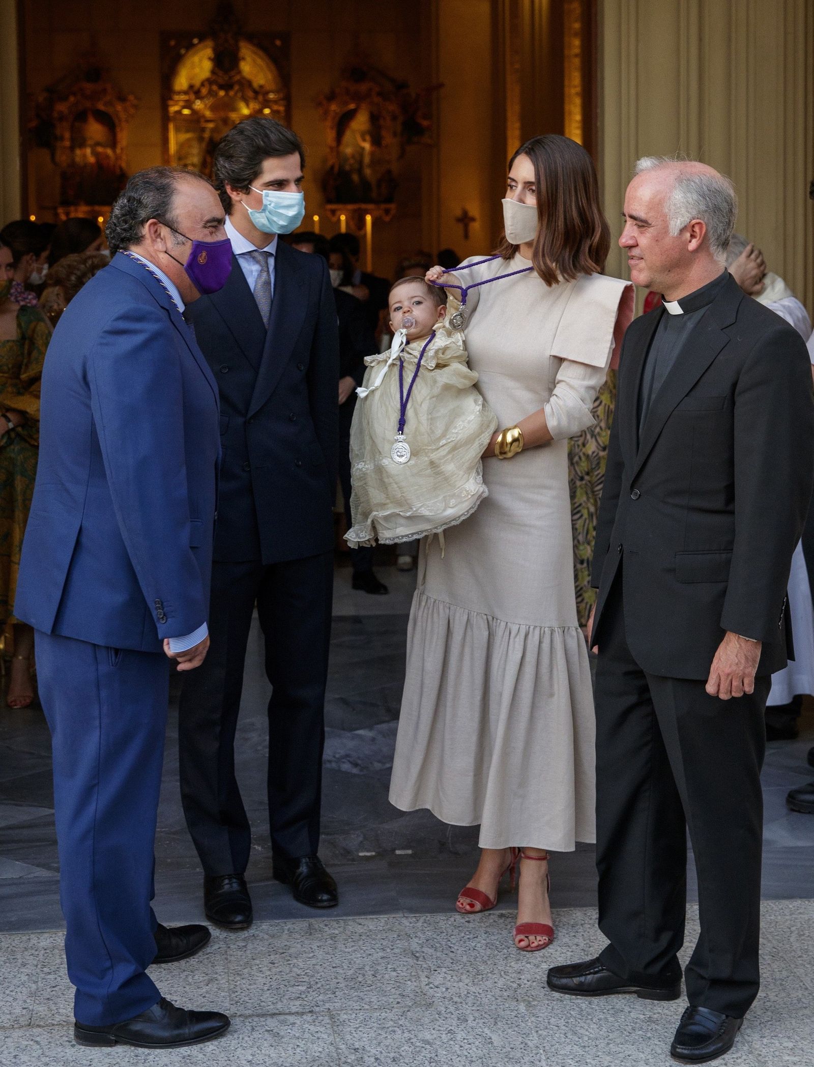 Los duques de Huéscar, con su hija, a las puertas del templo donde se recibió su bautismo.