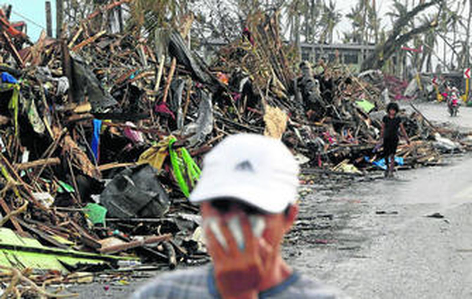 Supervivientes caminan entre los escombros tras el paso de 'Haiyan' por Tacloban.