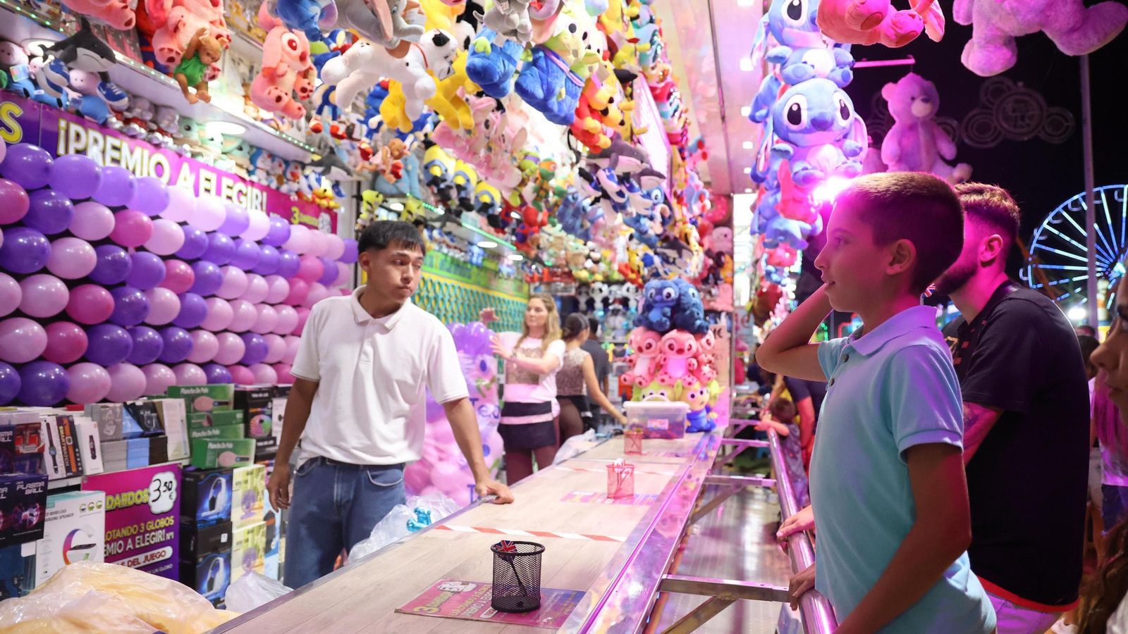 Un niño juega a explotar los globos en el primer día de Colombinas.